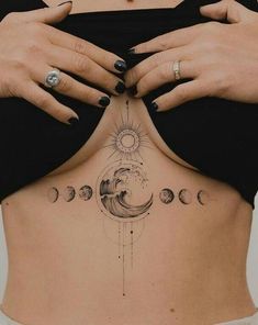 a woman's back with tattoos on her stomach and the moon in the sky