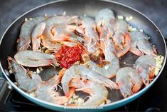 shrimp being cooked in a skillet on the stove top with spices and seasoning