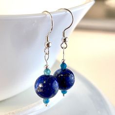 Beautiful and Unique. Handmade Lapis Lazuli with Faceted Apatite gemstone dangle drop earrings.  10mm Lapis Lazuli , 3mm Apatite.  Handmade with Solid Sterling Silver. Earth like.  Lightweight. Comes with meaning cards for each gemstone as seen in pictures. Returns or Exchanges accepted within 30 days of purchase.Feel free to message me with any questions you may have, I'm happy to answer them. Chip Bead Jewelry, Gold Round Earrings, Lapis Jewelry, Earrings Ideas, Gemstone Drop Earrings, Turquoise Crystal, Gemstone Beaded Necklace, With Meaning, Canada Post