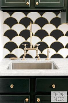 a black and white tile backsplash with brass faucet in the kitchen