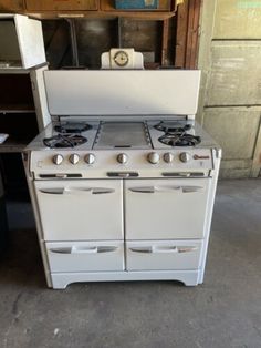 an old fashioned stove with two burners and one oven door is sitting in a garage