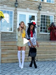 two women dressed in costumes talking on their cell phones while walking up the steps to a house