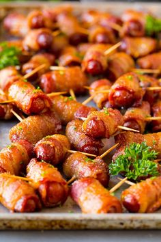 several skewered sausages with parsley on them are ready to be served