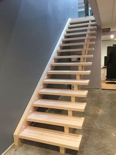 a set of stairs made out of wood and led lighting up the side of it