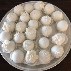 there are many white chocolates in the glass plate on the table, ready to be eaten