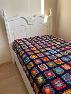 a bed with a colorful quilt on top of it