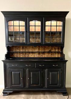 an old black china cabinet with glass doors