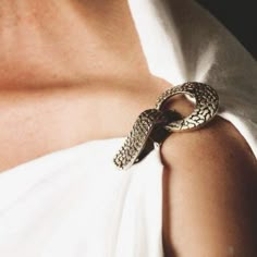 a close up of a person wearing a snake bracelet