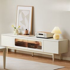 a white entertainment center with an old fashioned radio on it's sideboard in a living room