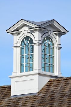 a tall white clock tower sitting on top of a roof