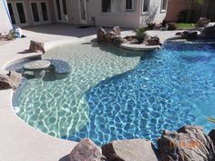 an outdoor pool with rocks and water features