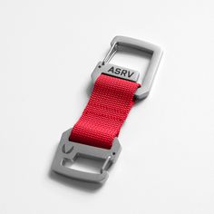 a red belt with the word abrv on it and a metal buckle attached to it