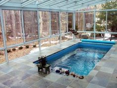 an indoor hot tub in the middle of a room with glass walls and flooring