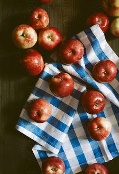 an image of apples that are on the table with napkins and blue checkered cloth