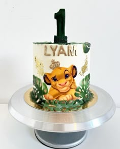 a lion themed birthday cake with the number one on it and an image of simba