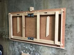 an unfinished wooden cabinet hanging on the wall