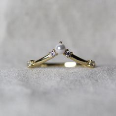 a close up of a gold ring with pearls and diamonds on it's side