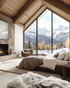 a bedroom with a large window overlooking the mountains and snow covered trees is pictured in this image