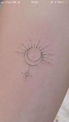 a small sun and moon tattoo on the back of a woman's left arm