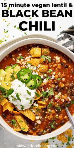 a white bowl filled with black bean chili and tortilla chips