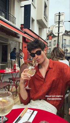 a man sitting at a table with a glass of wine