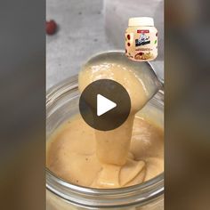 a spoon full of mayonnaise being poured into a jar