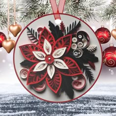 an ornament hanging from a christmas tree decorated with red and white ornaments in the snow