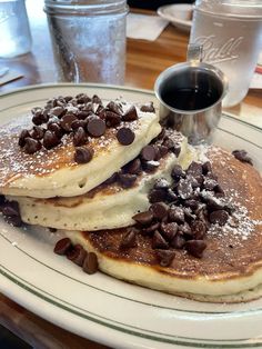 two pancakes with chocolate chips and syrup on a plate