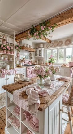 a kitchen filled with lots of pink flowers and dishes on top of a wooden table