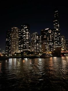 the city is lit up at night by the water