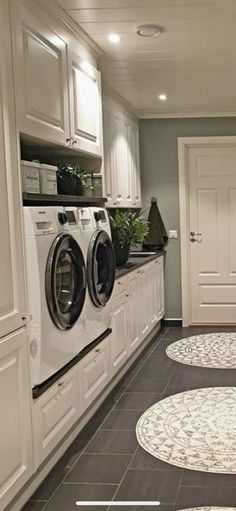 a laundry room with washer, dryer and cabinets on the floor next to each other