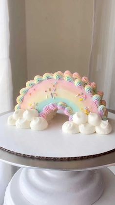 a white cake with a rainbow decoration on top