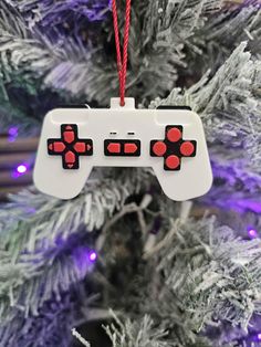 a christmas ornament hanging from a tree with a video game controller on it