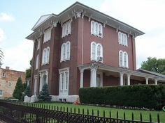 a large red brick building with white trim on the front and side of it's windows