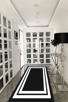 a black and white area rug in the middle of a hallway with glass doors on both sides