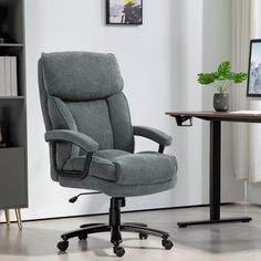 a gray office chair sitting in front of a computer desk with a monitor on it