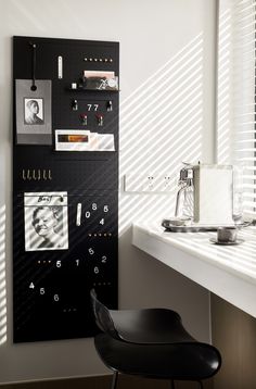 a black and white photo hanging on a wall next to a desk with a chair