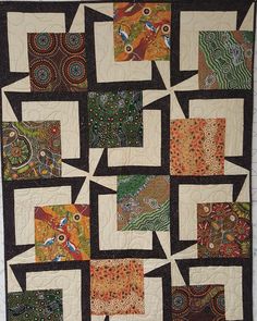 a quilted wall hanging with many different designs on it