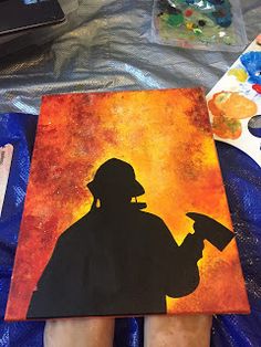 a person is holding a paintbrush in their hand and painting the silhouette of a man