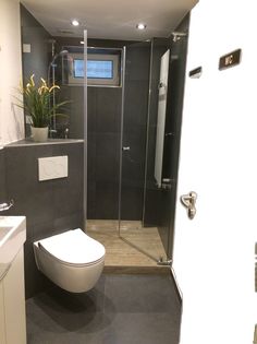 a bathroom with a toilet, sink and stand up shower stall in it's corner