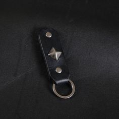 a black leather keychain with two metal rivets