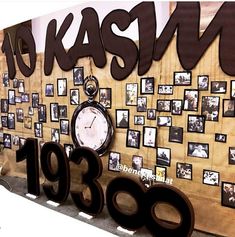 there is a wall with many pictures and a clock on it that says kasih