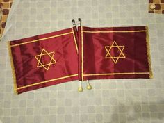 two red flags with gold star of david on them sitting on top of a table