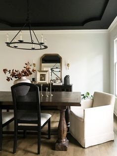 a dining room table with chairs and a chandelier hanging from it's ceiling