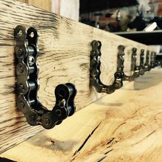 a close up of a metal hook on a wooden board with chains hanging from it