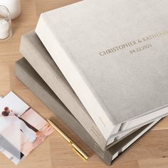 a couple's wedding album and pen on a table next to a glass of milk