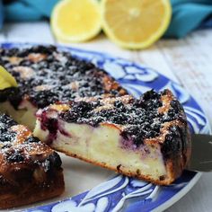 a blue and white plate topped with a slice of cake next to a lemon wedge