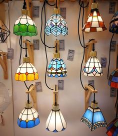 many different colored lamps are hanging on the wall