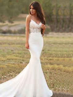 a woman in a white wedding dress posing for the camera with her hand on her hip