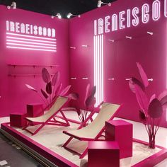 a pink display with two lounge chairs and some plants